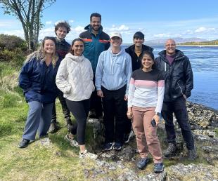 A group of 8 IDCORE Researchers by the shore