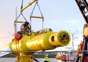 Offshore turbine lifted out of sea by a crane