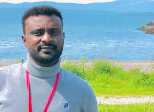 Mujahid Elobeid portrait photo with countryside and mountains in the background