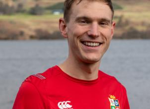 photo of Tom Summers with sea and mountains in the background